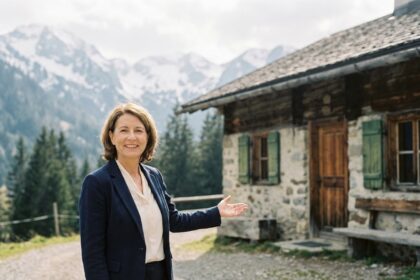 Agent immobilier de montagne présentant un chalet alpin avec montagnes enneigées en arrière-plan, illustration du changement apporté par une agence locale professionnelle