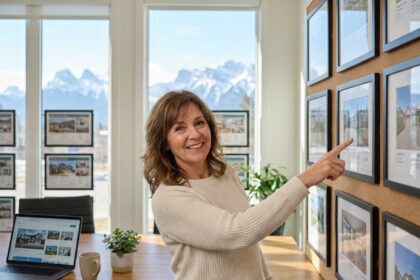 Agente immobilière montagne presentant proprietes clients bureau vue pics enneiges