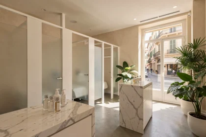 Intérieur luxueux d'un centre de soins du visage à Marseille avec cabines blanches et produits de beauté sur comptoir en marbre