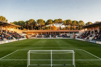 Vue panoramique d'un stade de football en Nouvelle-Aquitaine avec ses tribunes et son terrain verdoyant