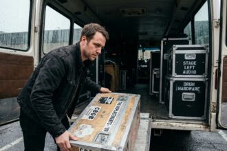 musicien chargeant un flight case d'occasion sur un bus de tournée, équipement de protection professionnel