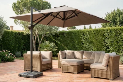 Parasol déporté taupe sur terrasse méditerranéenne avec mobilier en rotin et dalles en terre cuite